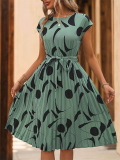 Tied pleated cap sleeve dress in green with black print, featuring a feminine silhouette and stylish design.