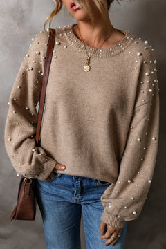 Pearl detail round neck long sleeve sweater in beige, paired with blue jeans, showcasing a stylish, casual look.