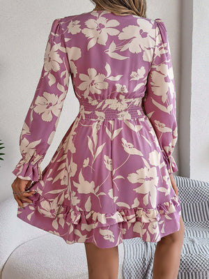 Back view of a tied ruffled printed long sleeve dress in purple floral pattern, highlighting its feminine design.