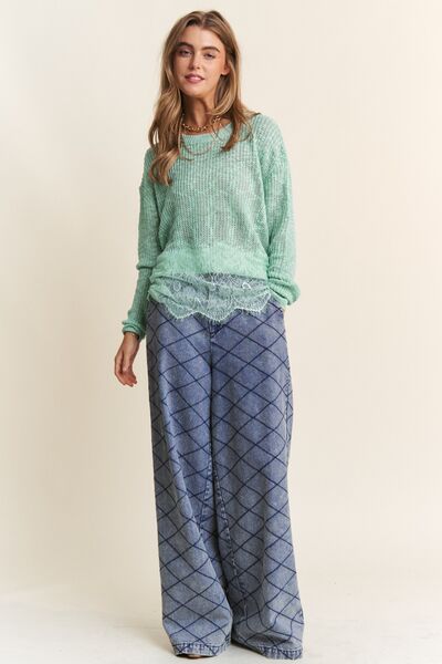 Woman wearing a mint green lace detail long sleeve knit top with wide-leg patterned pants.