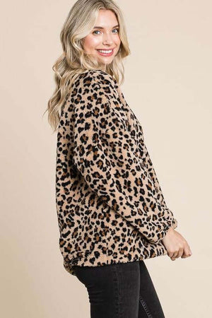 Woman wearing a leopard faux fur round neck top, showcasing its stylish and cozy design with a trendy print.