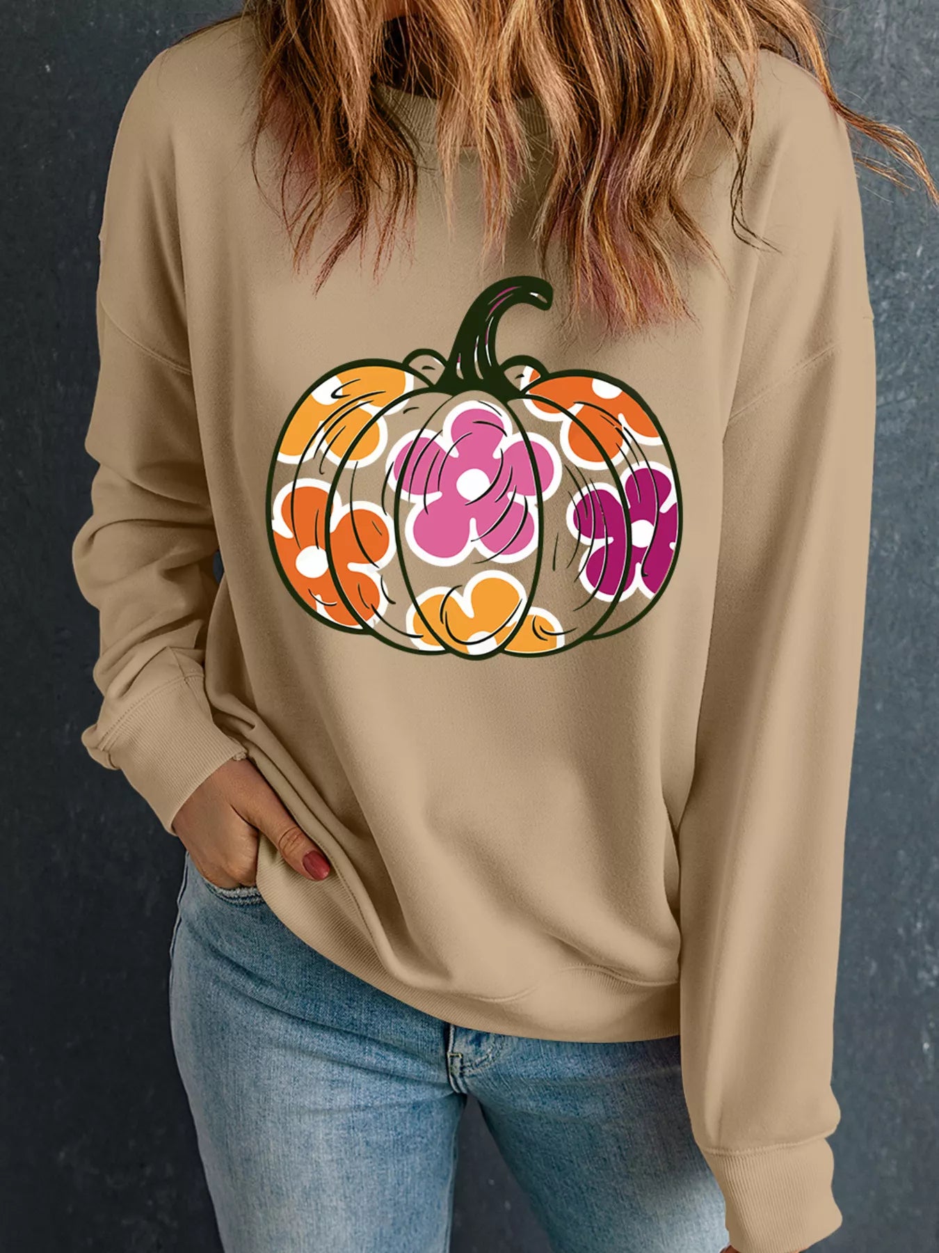 Halloween floral pumpkin graphic on a beige drop shoulder sweatshirt, showcasing a stylish fall look.