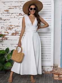 Full size slit v-neck sleeveless midi dress in white, styled with a large hat and woven bag, perfect for summer outings.