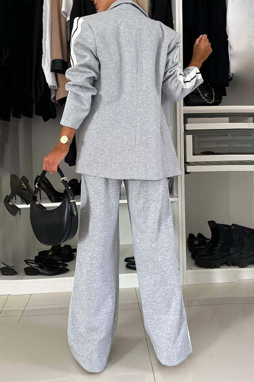 Woman wearing a full size contrast lapel collar gray top and pants set, showcasing stylish back detail.