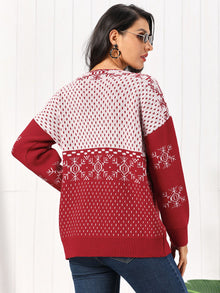 Back view of a woman wearing a Snowflake Button Down Cardigan in red and white, showcasing its cozy design and festive pattern.