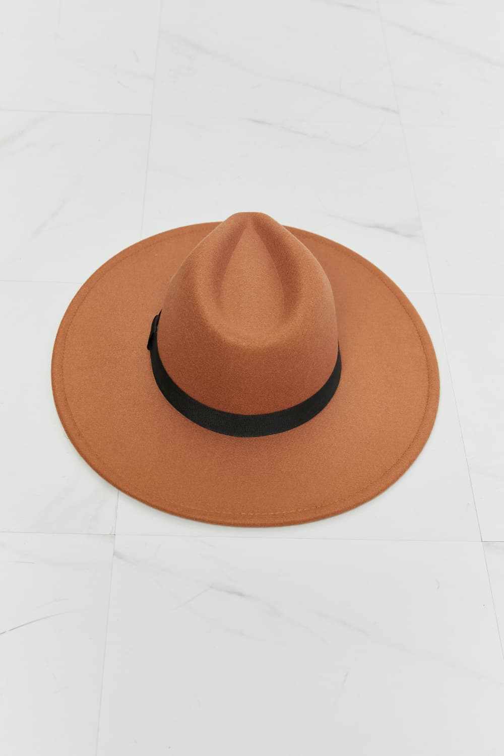 Tan fedora hat with black ribbon band, stylish and chic, perfect for enhancing any outfit.