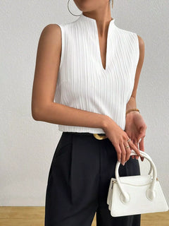 Texture Notched Sleeveless Top styled with high-waisted trousers and a white handbag.