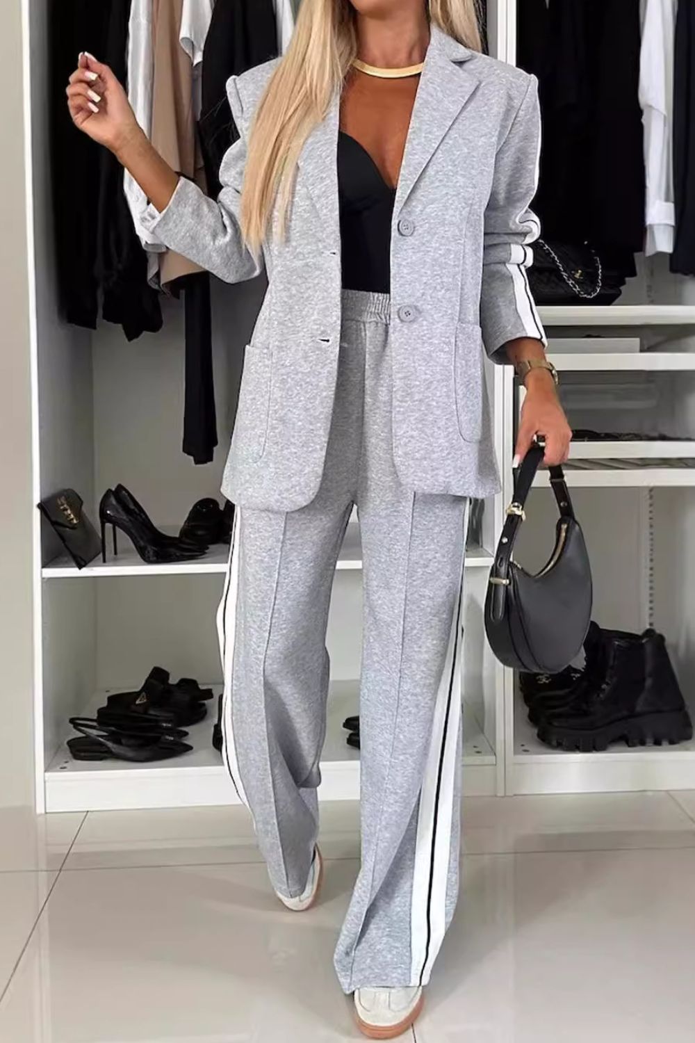 Woman wearing a stylish full-size, contrast lapel collar top and pants set, featuring a chic grey design with side stripes.