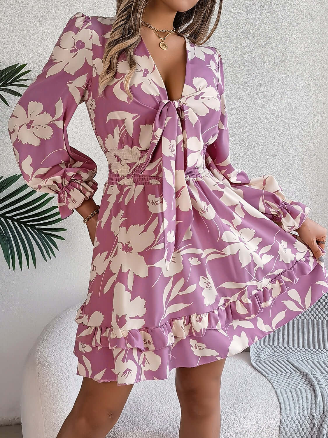 Tied ruffled long sleeve dress in floral print, featuring a cinched waist and playful ruffle hem, perfect for casual outings.