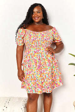 Devine Smocked Sweetheart Neck Flounce Sleeve Mini Dress on a model with floral pattern and off-shoulder design.