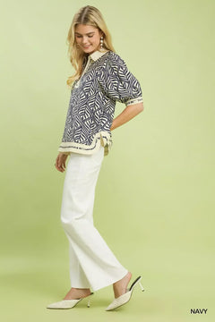 Umgee Geometric Leaf Print Popover Top displayed on a model with trendy white pants and stylish slip-on shoes.