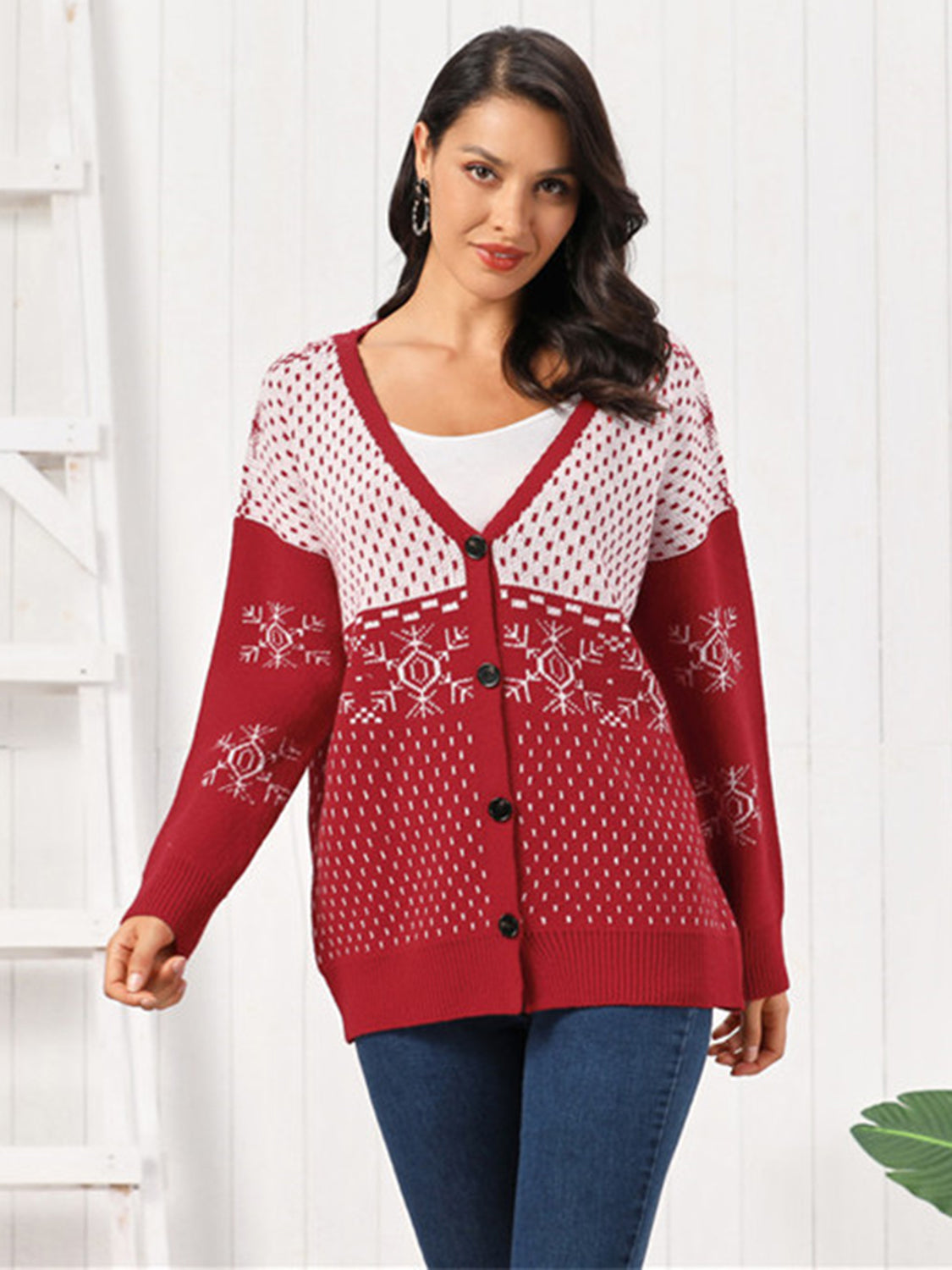 Snowflake Button Down Cardigan worn by a model, showcasing its festive red design and intricate patterns.