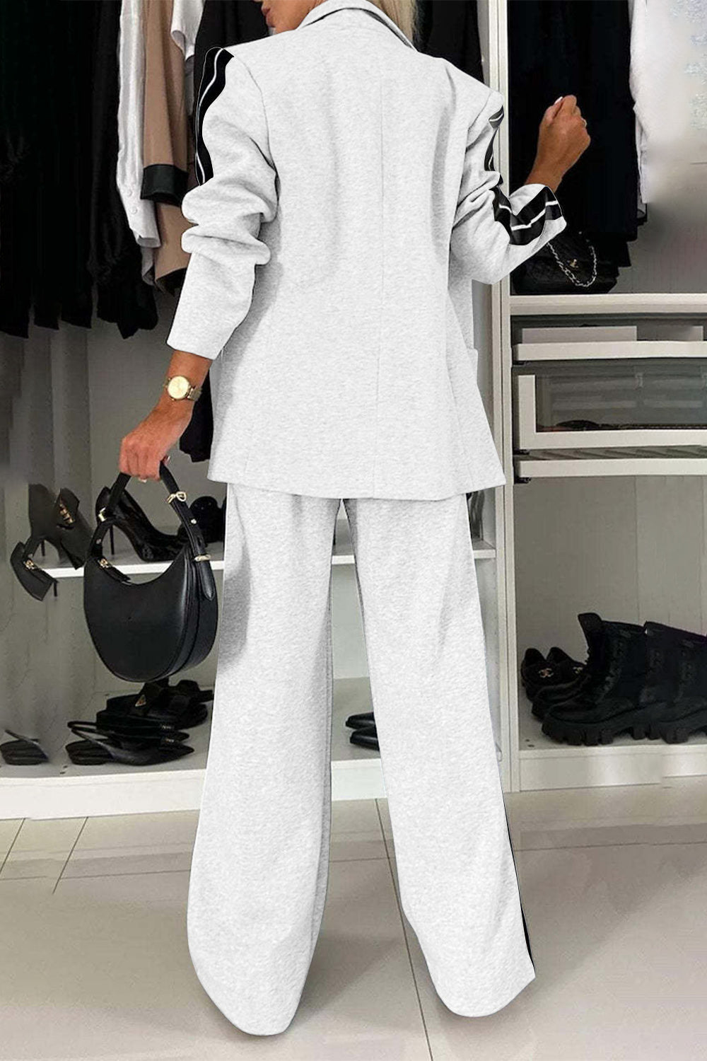 Woman wearing a full size contrast lapel collar top and pants set in light gray, showcasing a chic and stylish look.