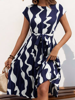 Tied pleated printed cap sleeve dress in navy and white with a flowy silhouette and stylish tie waist.