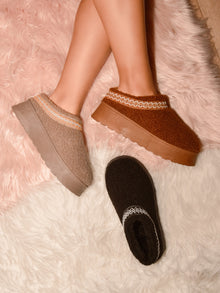 Cozy WILD DIVA embroidered trim platform sherpa boots in beige, brown, and black displayed on fuzzy surface.