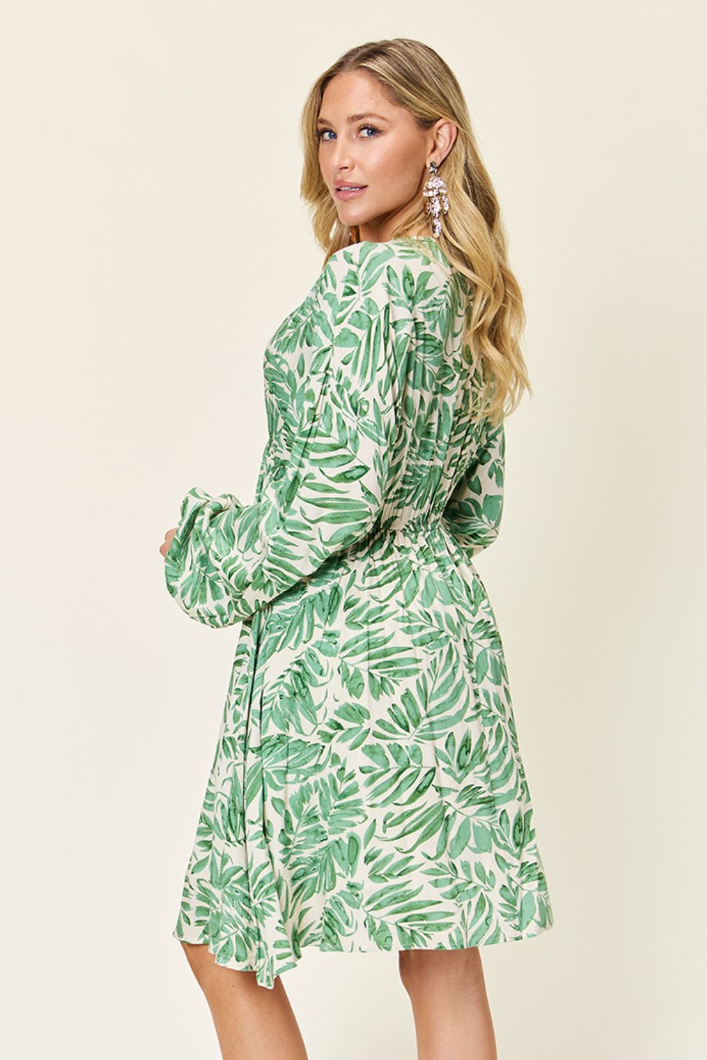 Model showcasing the Double Take Full Size Printed Ruched Balloon Sleeve Dress with a vibrant green leaf print.