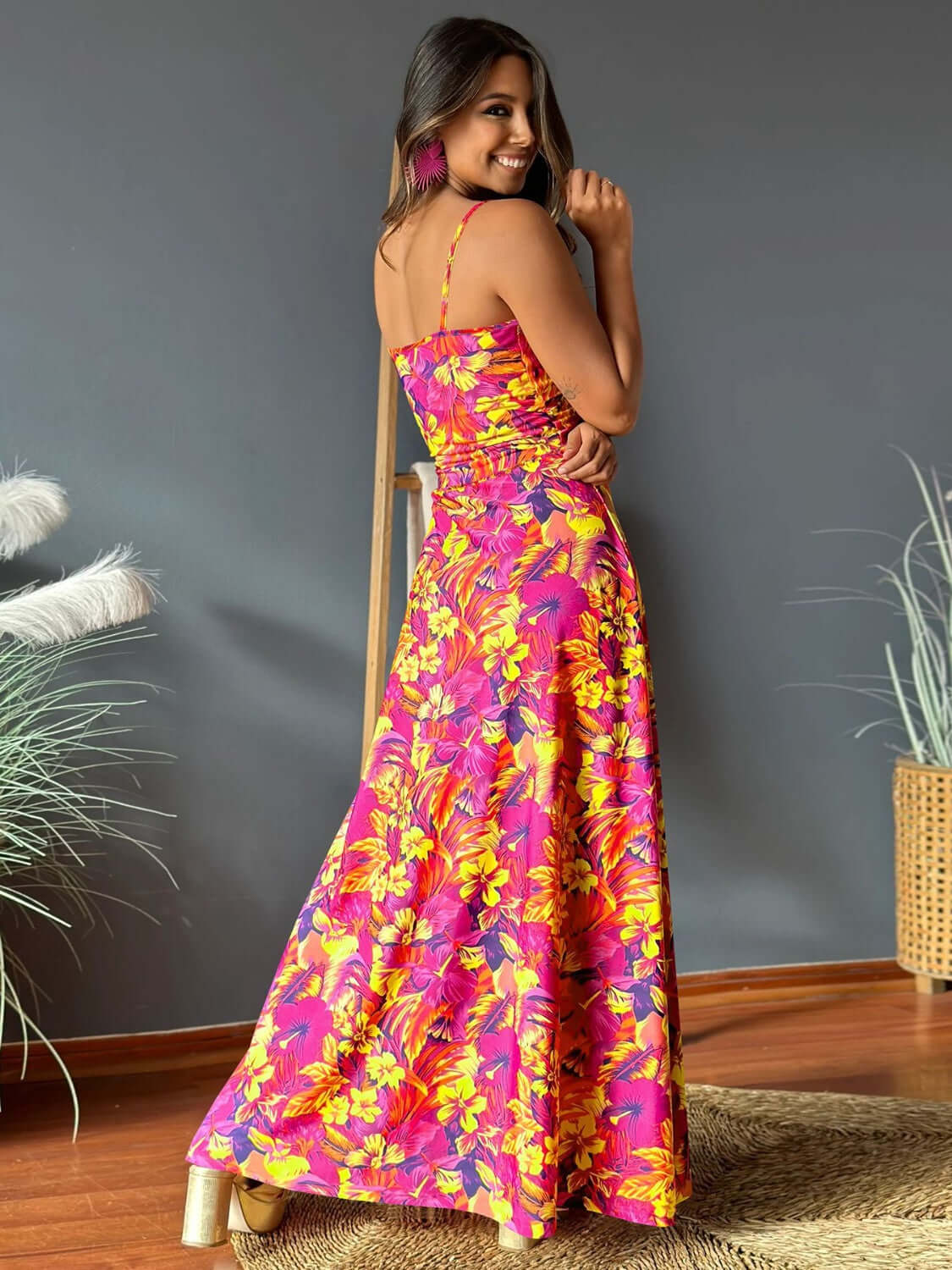 Woman wearing a twisted printed V-neck cami dress in vibrant floral patterns, showcasing a stylish back view.