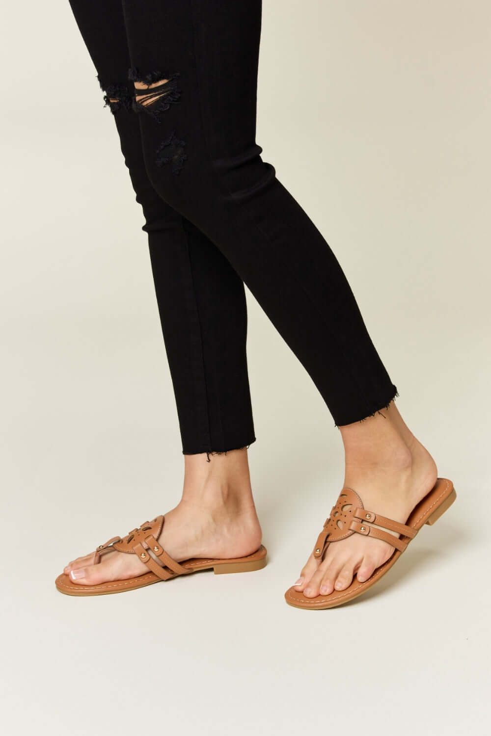 Chic cutout PU leather open toe sandals paired with black ripped jeans for a stylish look.