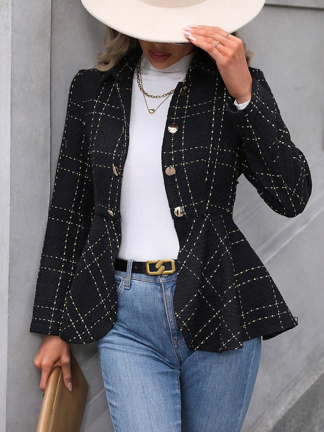 Ruffle hem collared blazer in black check pattern, styled with blue jeans and a wide-brim hat.