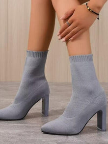 Pointed toe block heel boots in light gray with a sleek design, perfect for stylish outfits. High heel height for a chic look.