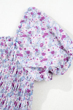 Detail of tiered floral shirred fabric showcasing purple and blue flowers on a light background.