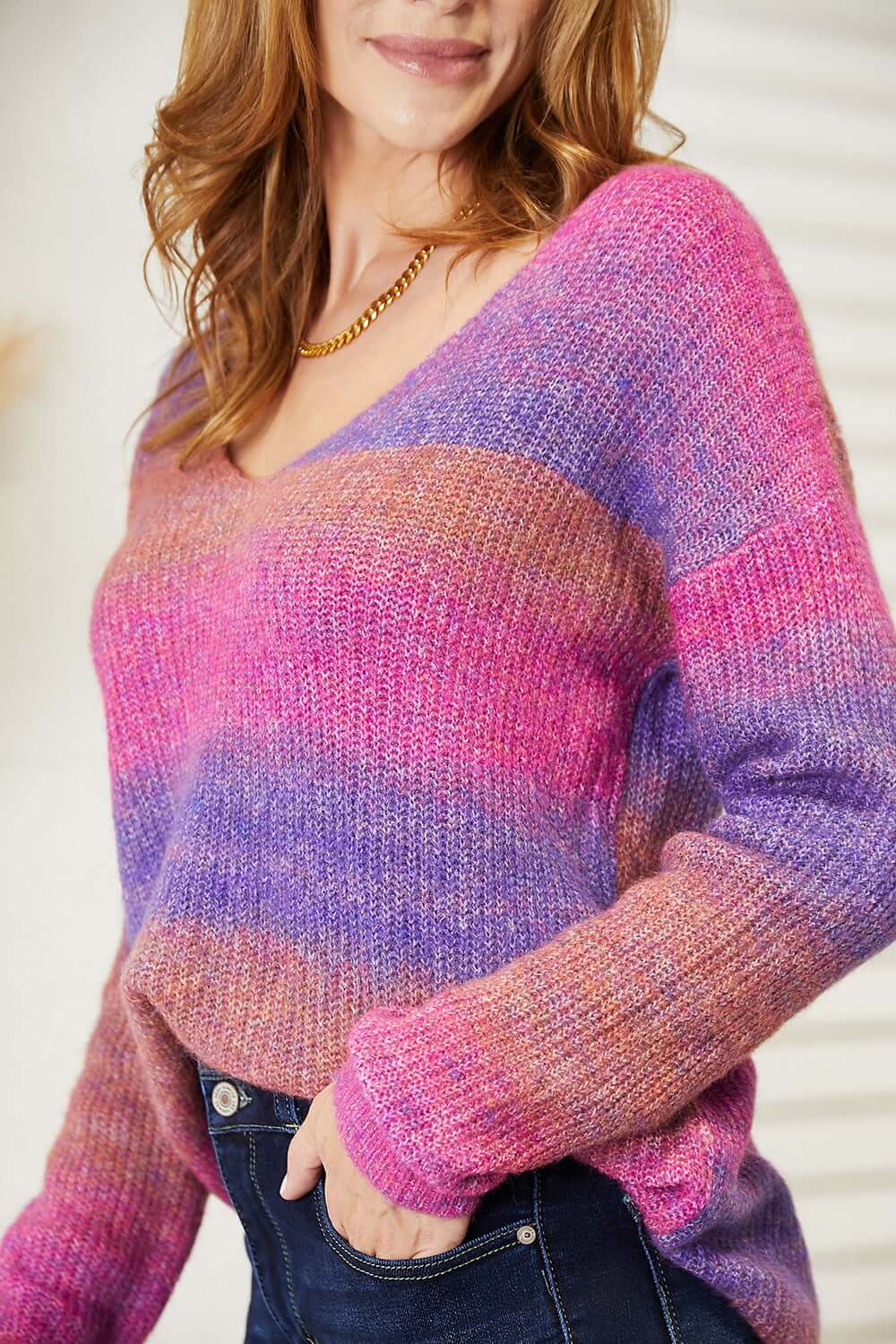 Angel Wings Multicolored Rib-Knit V-Neck Knit Pullover worn by a woman, showcasing its vibrant purple and pink hues.
