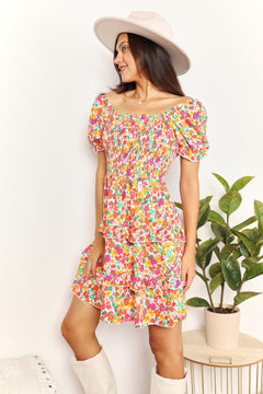 Devine Smocked Sweetheart Neck Flounce Sleeve Mini Dress featuring vibrant floral patterns and playful flounce sleeves.