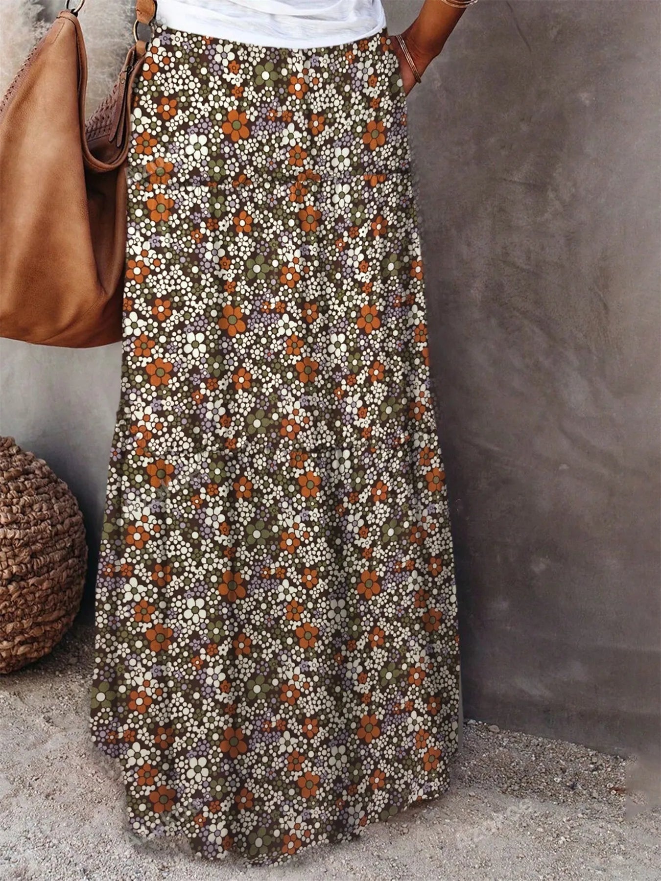 Floral print maxi skirt with earthy tones, perfect for casual outings, paired with a simple white top and a stylish handbag.