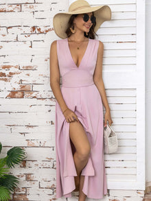 Full size pink slit V-neck sleeveless midi dress with a ruffle hem, styled with a wide-brim hat and sunglasses.