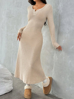 Model wearing a ribbed long sleeve knit dress in beige, paired with cozy slippers, showcasing a stylish yet comfortable look.