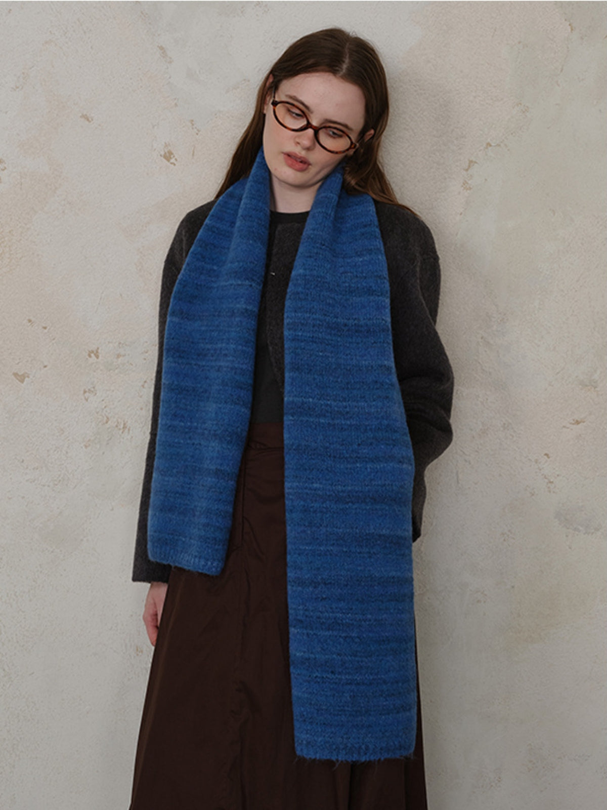 Model wearing a blue striped detail knit scarf, showcasing soft fur material and stylish design.