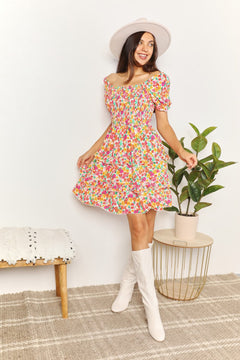 Devine Smocked Sweetheart Neck Flounce Sleeve Mini Dress worn by a model, featuring floral pattern and playful style.