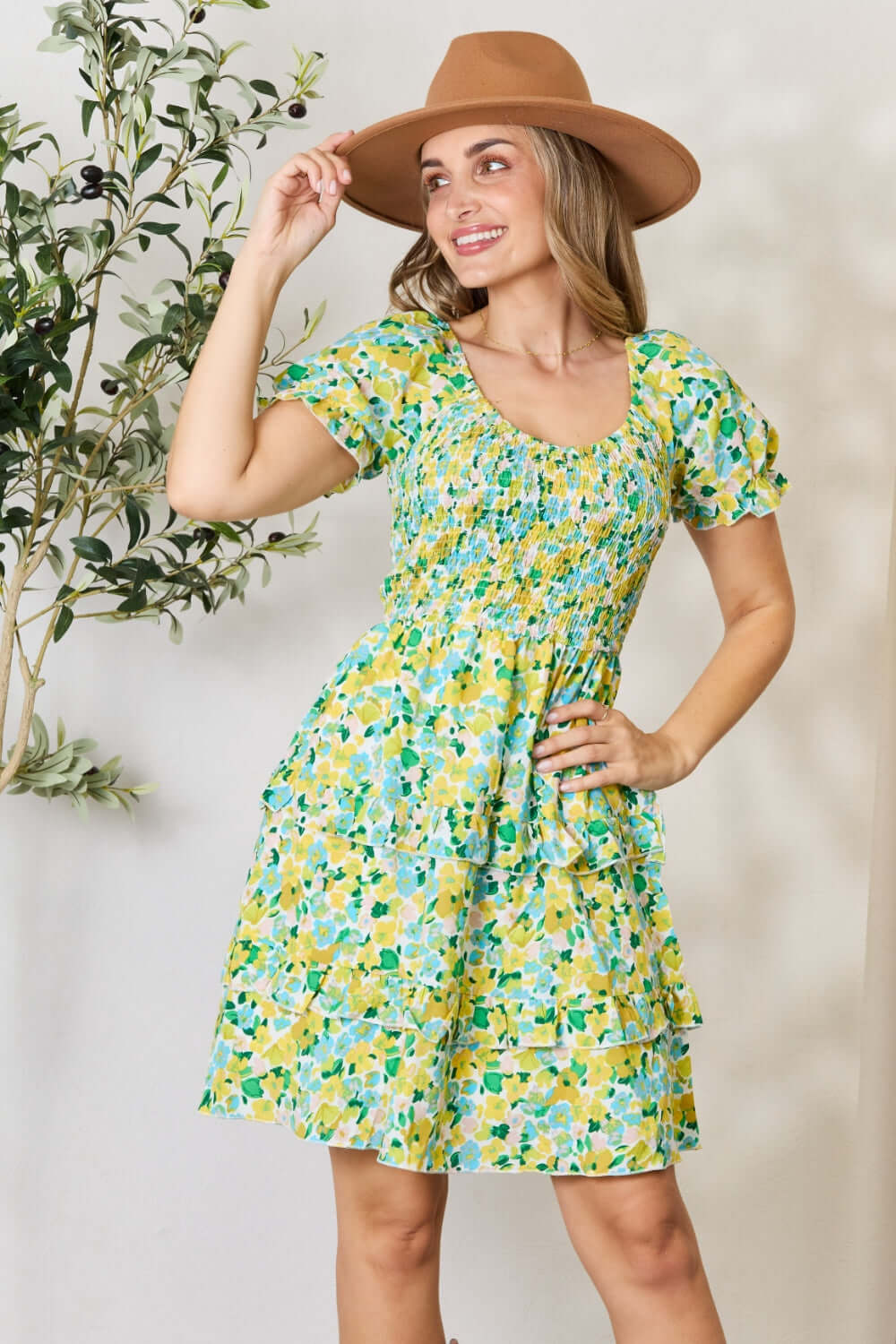 This floral patterned mini dress features a scoop neck, adding a touch of femininity. The smocked detailing adds both texture and a flattering fit. The short flounce sleeves lend a playful and romantic feel to the dress. With its mini length, this dress is perfect for showing off your legs. Its charming design will make you feel confident and stylish.