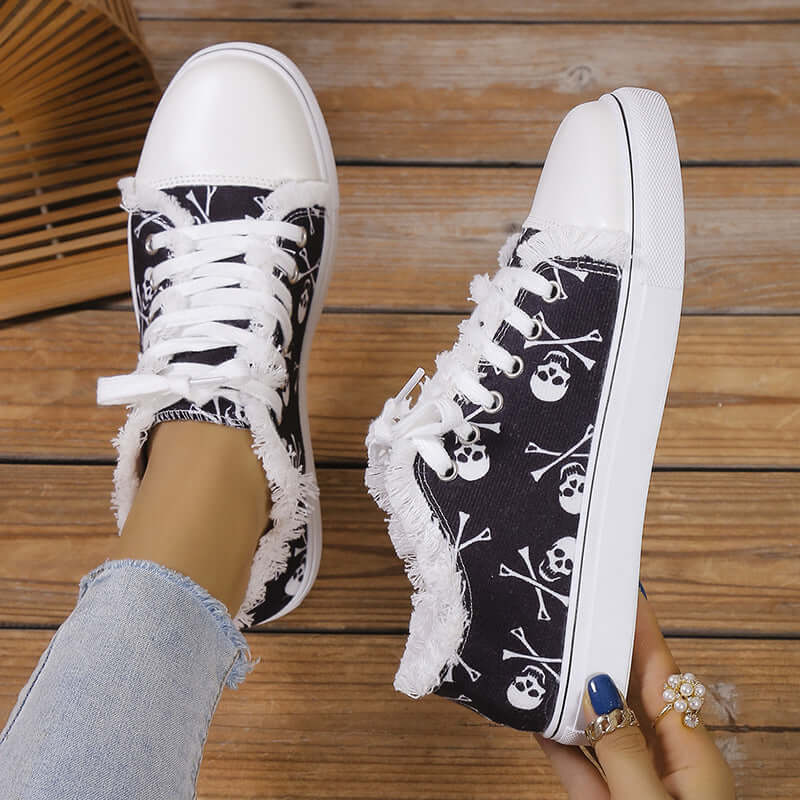 Black raw hem canvas sneakers with skull print and white rubber soles, stylish and comfortable flats.