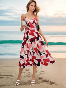 Pleated geometric spaghetti strap dress in red, pink, and black patterns, perfect for summer outings at the beach.