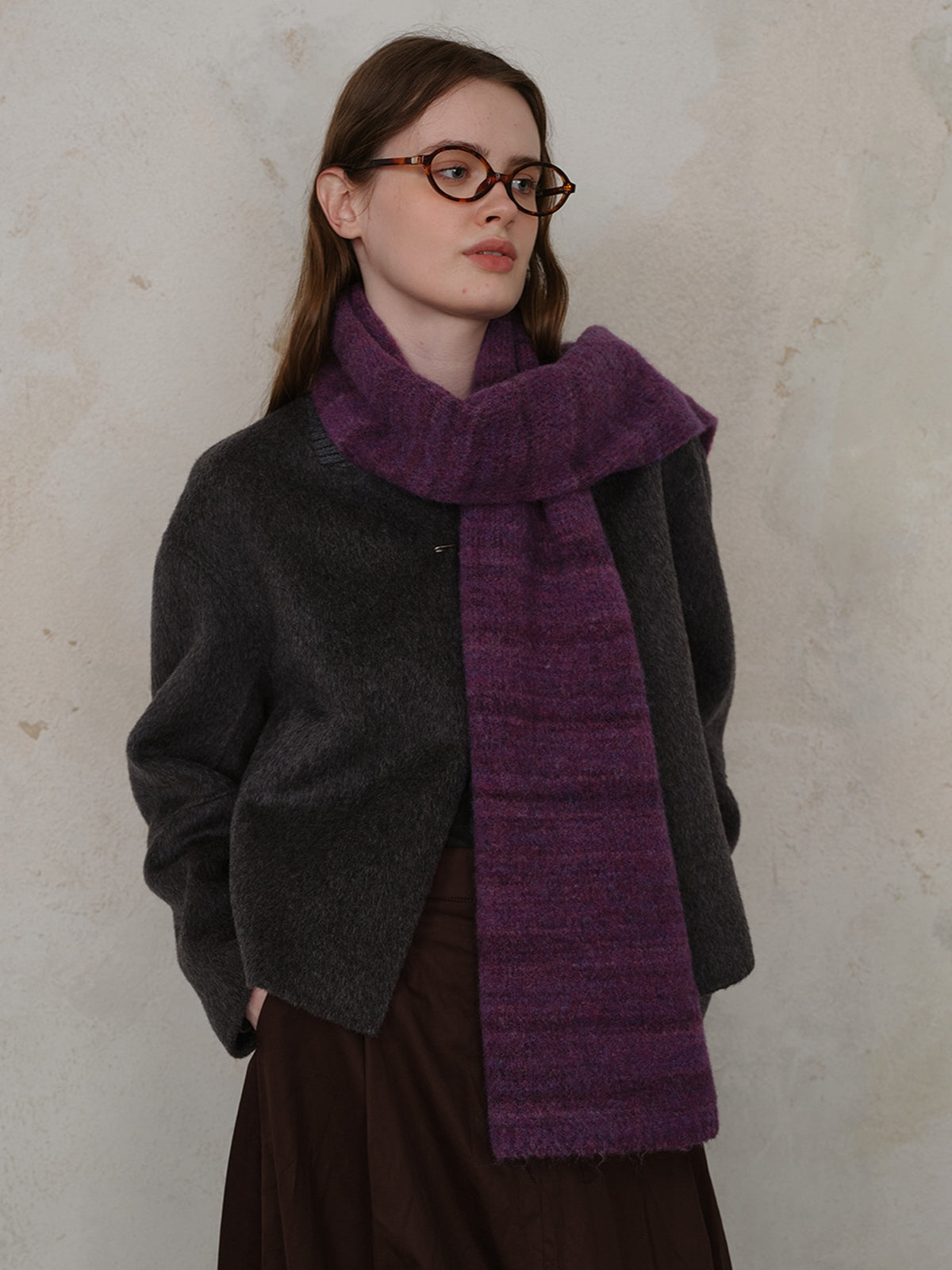 Model wearing a stylish striped detail knit scarf and a grey jacket, showcasing warmth and elegance.