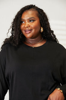 Double Take Seam Detail Round Neck Long Sleeve Top worn by a model, featuring seam detail and a round neck in a stylish black design.