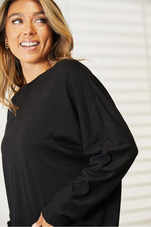 Model wearing the Double Take Seam Detail Round Neck Long Sleeve Top in black, showcasing its chic elegance and comfort.
