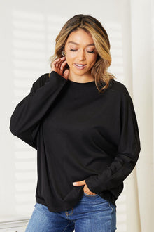 Double Take Seam Detail Round Neck Long Sleeve Top worn by a model, showing its elegant fit and versatile black design.
