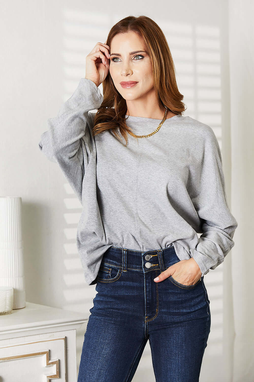 Double Take Seam Detail Round Neck Long Sleeve Top worn with high-waisted jeans, showcasing its casual elegance.