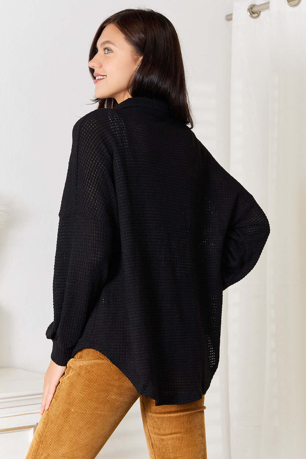 Back view of a woman wearing the Double Take Waffle-Knit Collared Neck Dropped Shoulder Shirt in black.