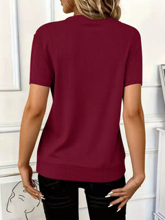 Back view of a woman wearing a Half Zip Short Sleeve Top in burgundy, featuring ribbed texture and short sleeves.