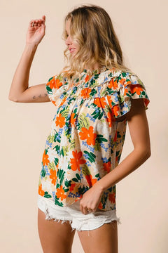 BiBi Multi Color Floral Print Woven Top with vibrant floral pattern and ruffled sleeves, styled with shorts.