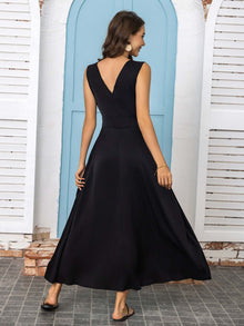 Back view of a woman wearing a full size slit v-neck sleeveless midi dress in black, showcasing flowing design and elegant silhouette.