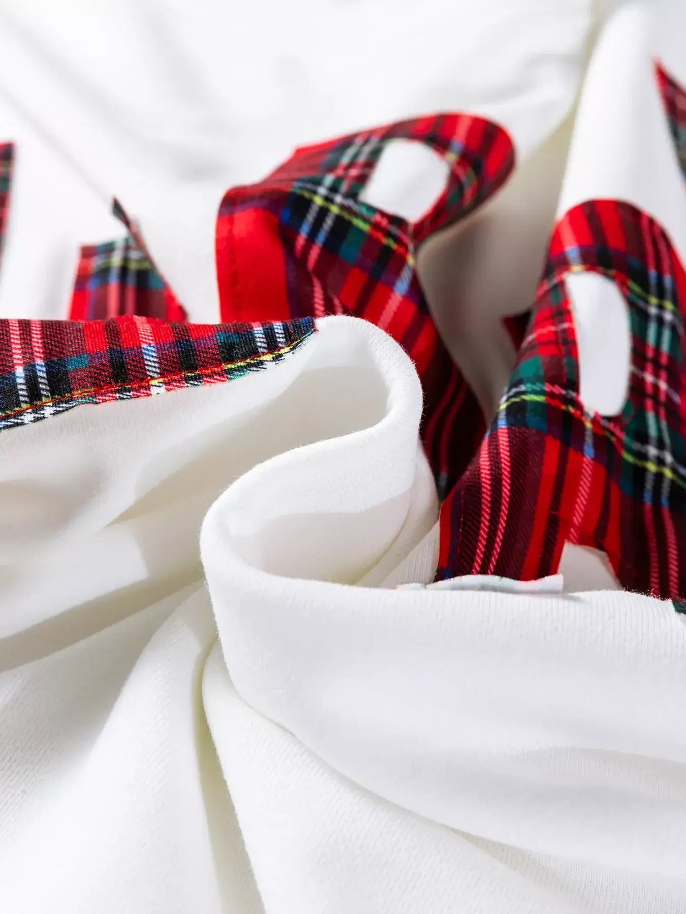Close-up of the fabric on the Plaid MERRY Christmas Vacation Sweatshirt showcasing vibrant plaid patterns.