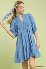 Umgee Smocked Bib Ruffle Hem Babydoll Dress in light blue with puff sleeves and ruffle hem, worn by a smiling model.