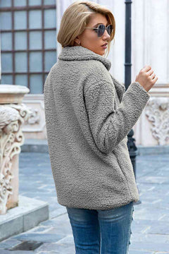 Stylish woman wearing a gray lapel collar sherpa coat, showcasing a casual urban look with sunglasses.