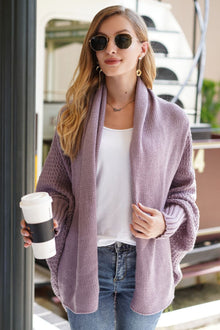 Model wearing a lavender dolman sleeve open front cardigan, holding a coffee cup, styled casually with sunglasses.