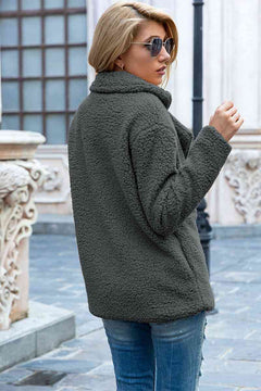 Model wearing a solid green full size lapel collar sherpa coat in an urban setting.
