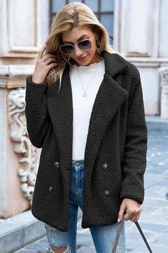 Woman wearing a black sherpa coat with lapel collar, styled for a casual urban look, featuring double-breasted buttons.